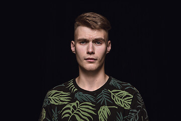 Image showing Close up portrait of young man isolated on black studio background