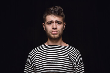 Image showing Close up portrait of young man isolated on black studio background