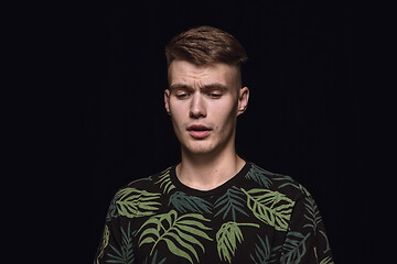 Image showing Close up portrait of young man isolated on black studio background