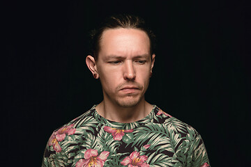 Image showing Close up portrait of young man isolated on black studio background