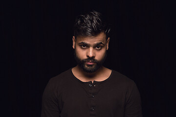 Image showing Close up portrait of young man isolated on black studio background