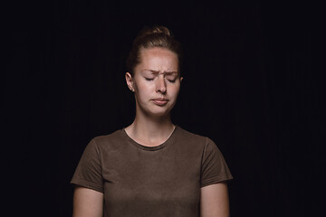 Image showing Close up portrait of young woman isolated on black studio background