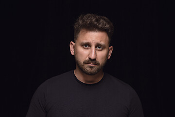 Image showing Close up portrait of young man isolated on black studio background