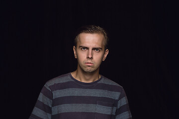 Image showing Close up portrait of young man isolated on black studio background