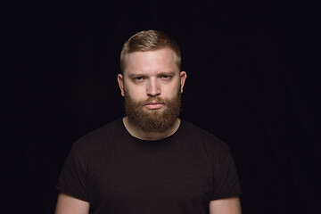 Image showing Close up portrait of young man isolated on black studio background