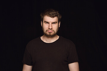 Image showing Close up portrait of young man isolated on black studio background