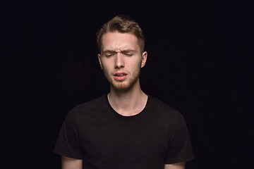 Image showing Close up portrait of young man isolated on black studio background