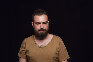 Image showing Close up portrait of young man isolated on black studio background