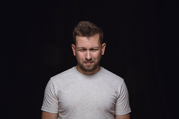 Image showing Close up portrait of young man isolated on black studio background