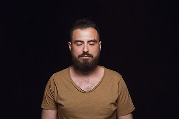 Image showing Close up portrait of young man isolated on black studio background