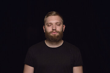 Image showing Close up portrait of young man isolated on black studio background