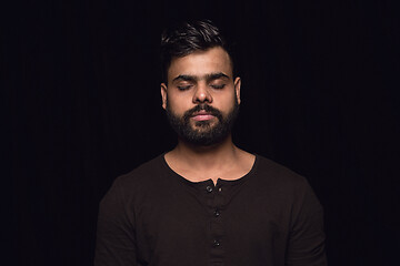 Image showing Close up portrait of young man isolated on black studio background