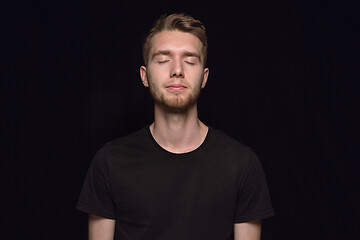 Image showing Close up portrait of young man isolated on black studio background