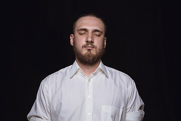 Image showing Close up portrait of young man isolated on black studio background