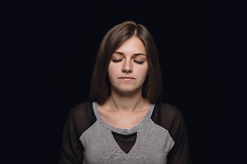 Image showing Close up portrait of young woman isolated on black studio background