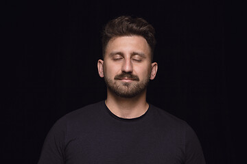 Image showing Close up portrait of young man isolated on black studio background