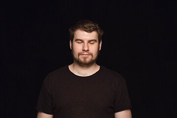 Image showing Close up portrait of young man isolated on black studio background