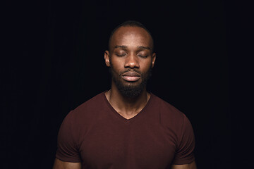 Image showing Close up portrait of young man isolated on black studio background