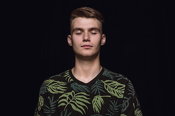 Image showing Close up portrait of young man isolated on black studio background