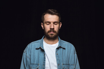 Image showing Close up portrait of young man isolated on black studio background