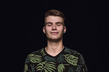 Image showing Close up portrait of young man isolated on black studio background