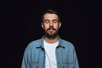 Image showing Close up portrait of young man isolated on black studio background