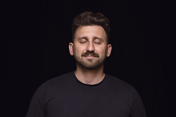 Image showing Close up portrait of young man isolated on black studio background