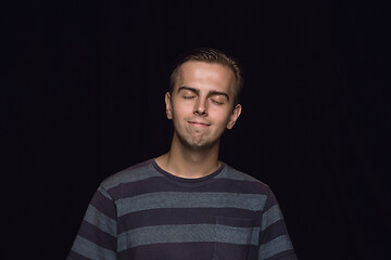 Image showing Close up portrait of young man isolated on black studio background
