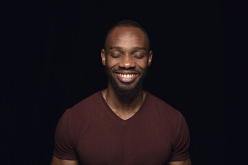 Image showing Close up portrait of young man isolated on black studio background