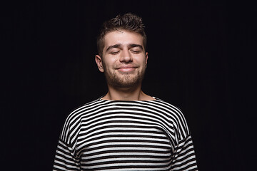 Image showing Close up portrait of young man isolated on black studio background