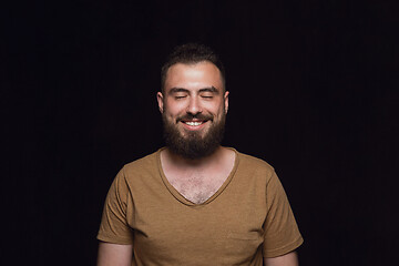 Image showing Close up portrait of young man isolated on black studio background