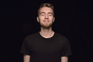 Image showing Close up portrait of young man isolated on black studio background