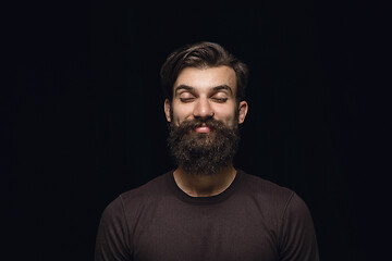 Image showing Close up portrait of young man isolated on black studio background