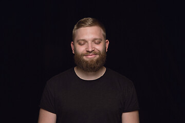 Image showing Close up portrait of young man isolated on black studio background