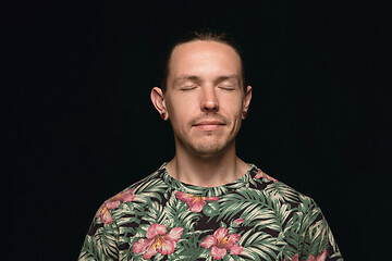 Image showing Close up portrait of young man isolated on black studio background