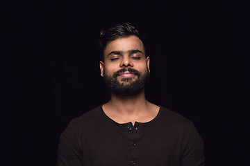 Image showing Close up portrait of young man isolated on black studio background