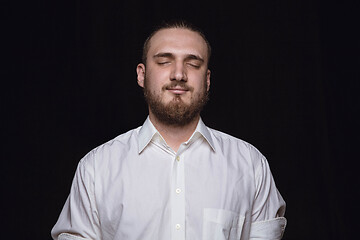 Image showing Close up portrait of young man isolated on black studio background