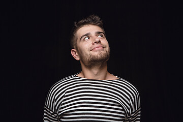 Image showing Close up portrait of young man isolated on black studio background