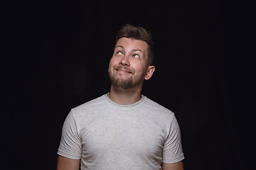 Image showing Close up portrait of young man isolated on black studio background