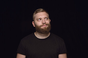 Image showing Close up portrait of young man isolated on black studio background