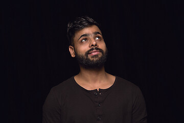 Image showing Close up portrait of young man isolated on black studio background