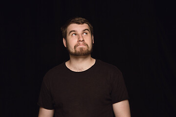 Image showing Close up portrait of young man isolated on black studio background