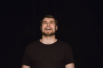 Image showing Close up portrait of young man isolated on black studio background