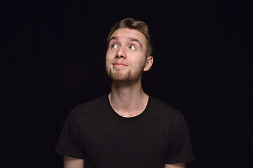 Image showing Close up portrait of young man isolated on black studio background