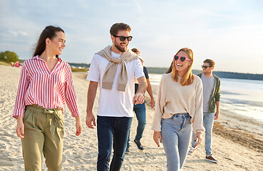 Image showing happy friends walking along summer beach