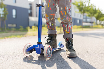 Image showing close up of little boy with scooter on road