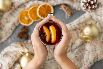 Image showing hands with glass of hot mulled wine on christmas