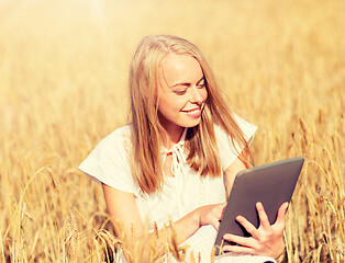 Image showing happy young woman with tablet pc on cereal field