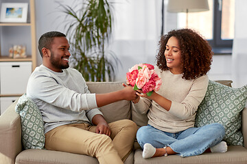 Image showing happy couple with bunch of flowers at home