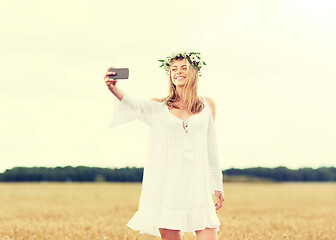 Image showing happy young woman taking selfie by smartphone